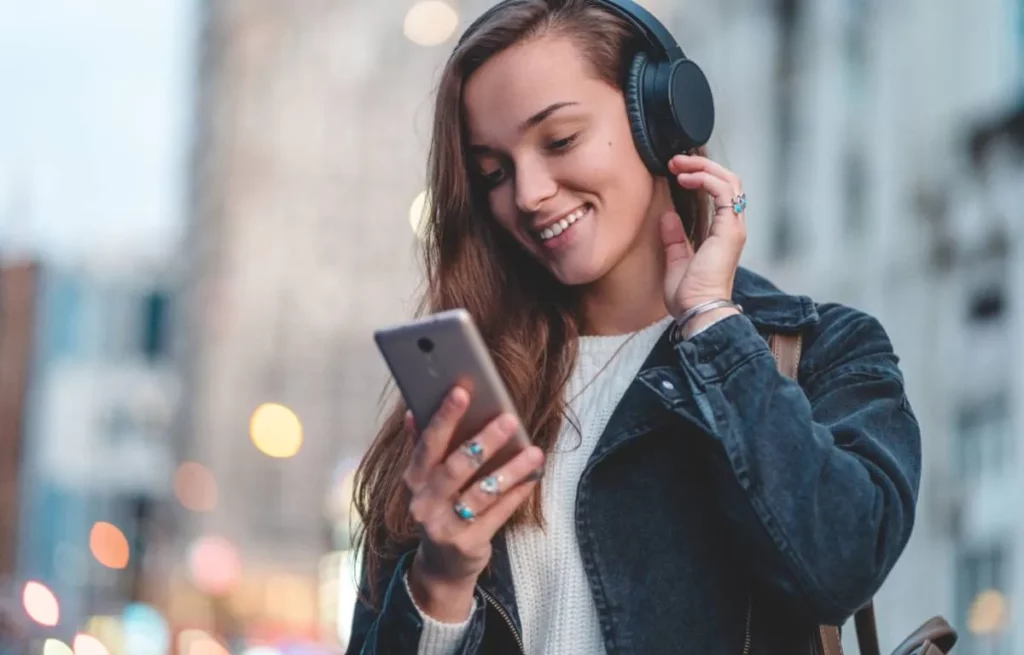 femme qui écoute de la musique avec son casque supra-auriculaire branché au téléphone